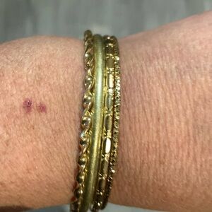 Four bangle bracelets gold in colour